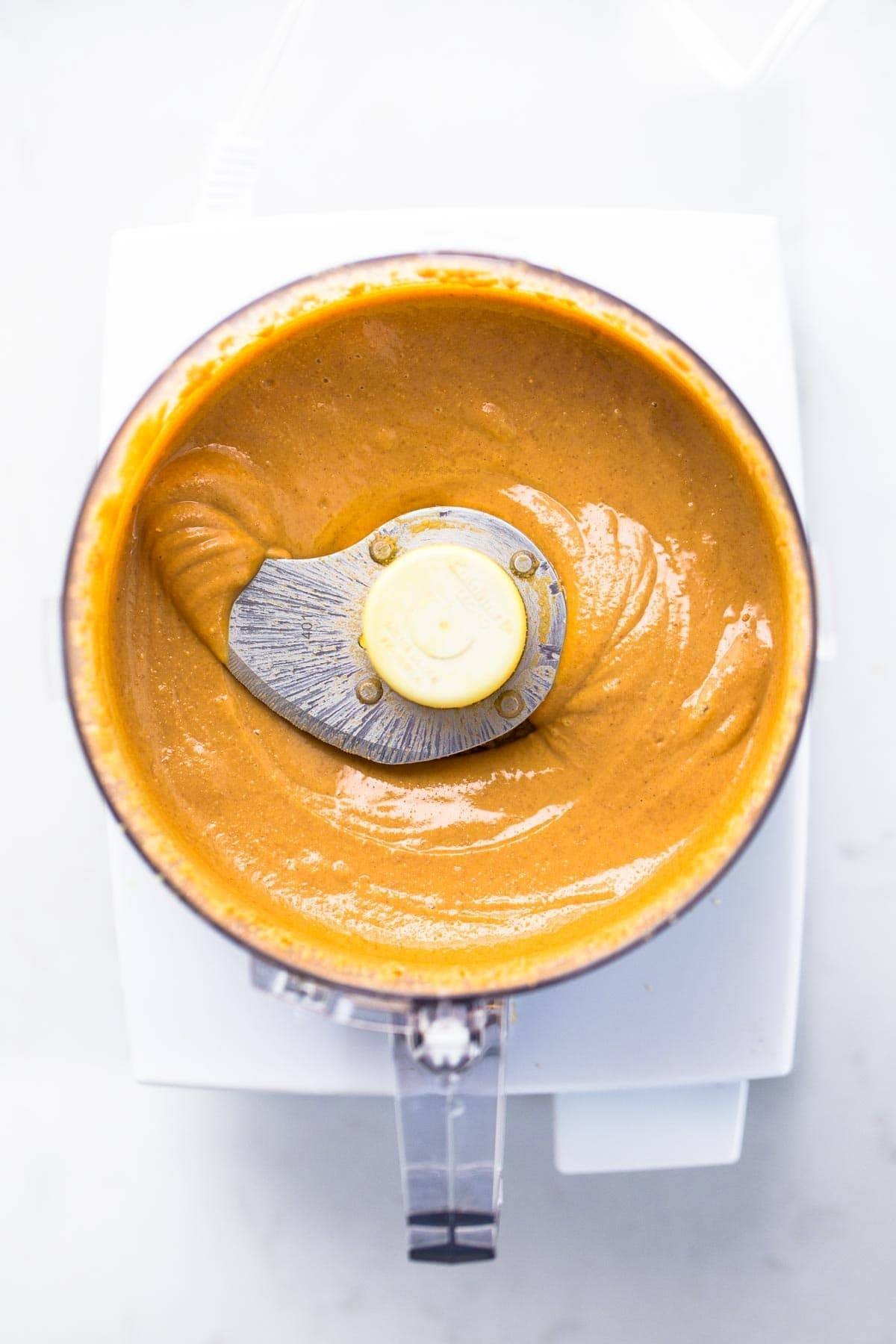 Creamy almond butter being made in a food processor, showcasing the appliance's capability to create homemade nut butters.