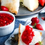 Freshly made strawberry sauce being spooned onto a slice of angel food cake, showcasing its vibrant color and perfect consistency