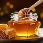 Golden honey dripping from a wooden dipper into a glass jar, showcasing its viscous texture and inviting sweetness