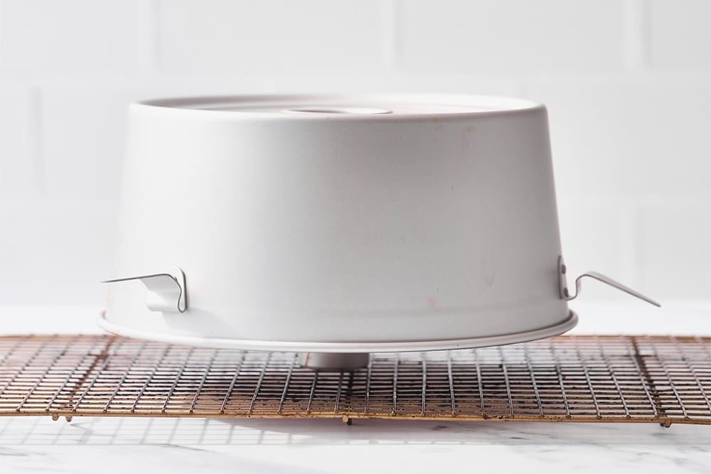 Showing how to cool angel food cake in the correct kind of pan, for best results