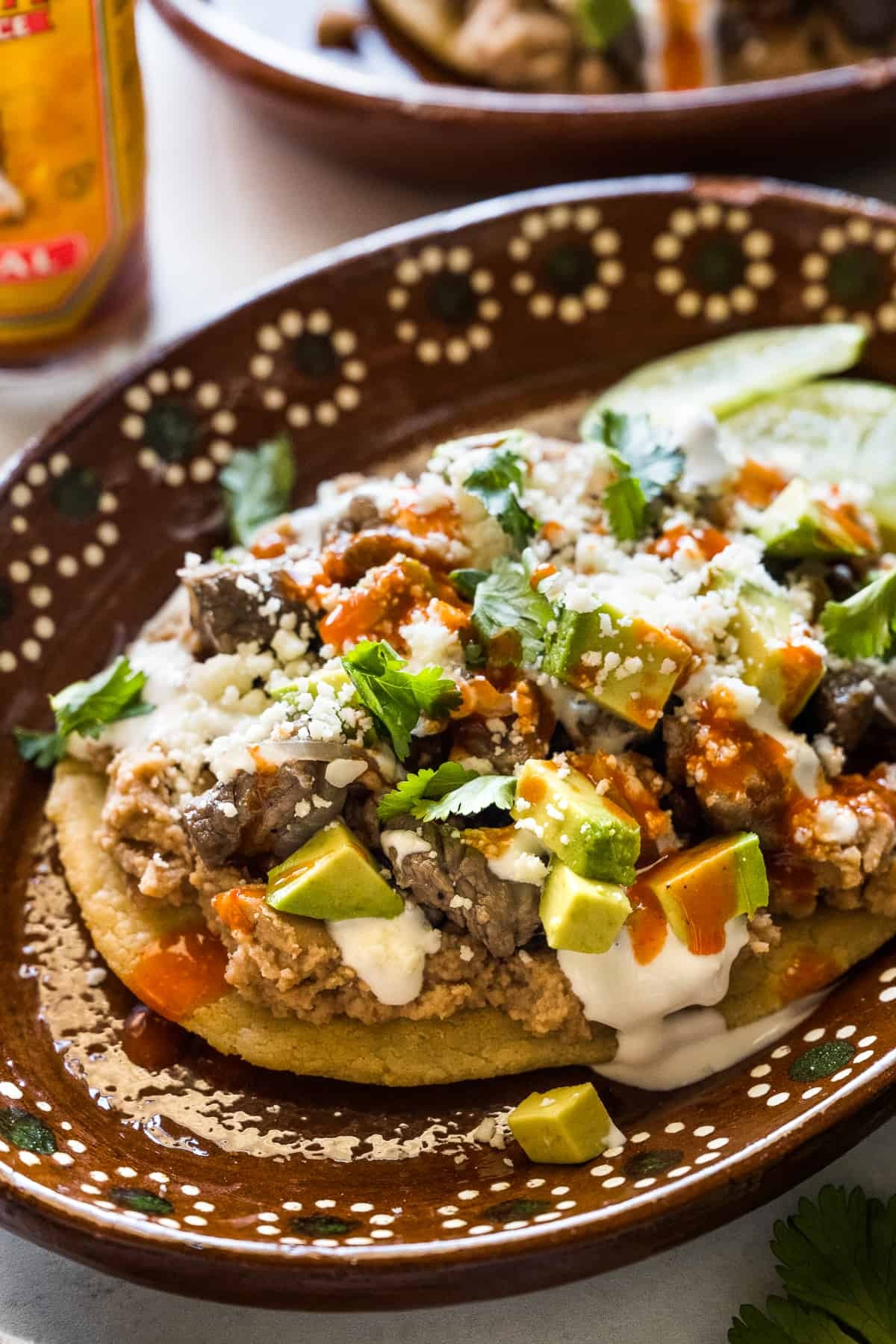Traditional Mexican Huaraches, showcasing the oblong masa base topped with beans, meat, cheese, and salsa, a staple of Mexican street food.