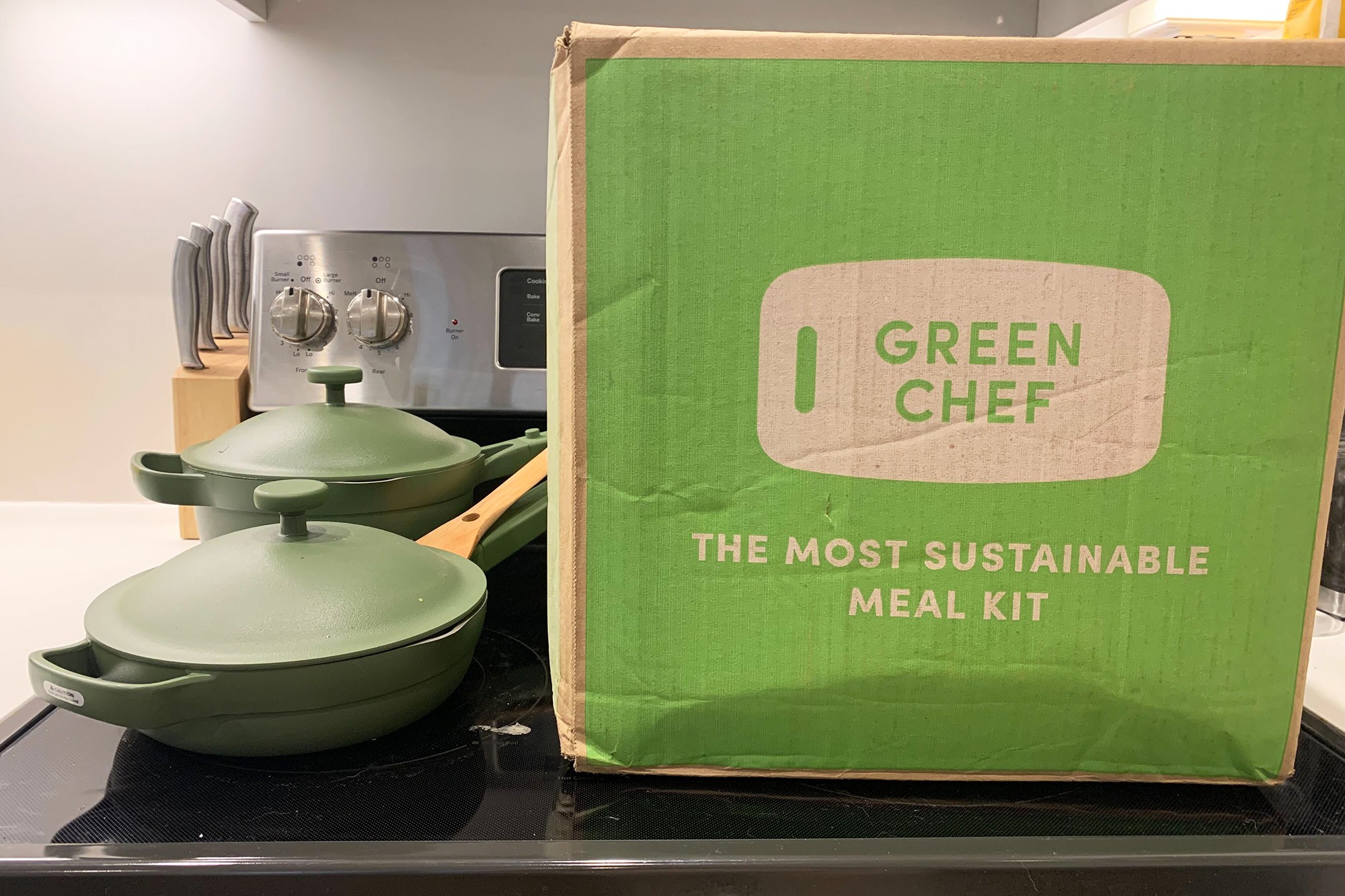 A box of Green Chef and two green pots and pans on a stove