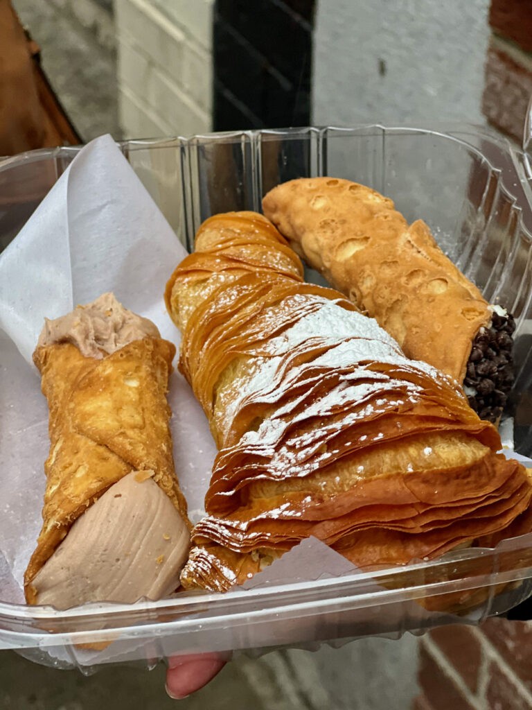Cannolis and other Italian Pastries displayed in a bakery case