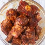Raw oxtails covered in seasoning in a bowl