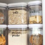 Kitchen cabinet organization with OXO storage bins and vinyl labels