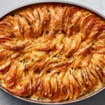 Cheesy Hasselback potato gratin with melted browned cheese, packed and ruffly potatoes