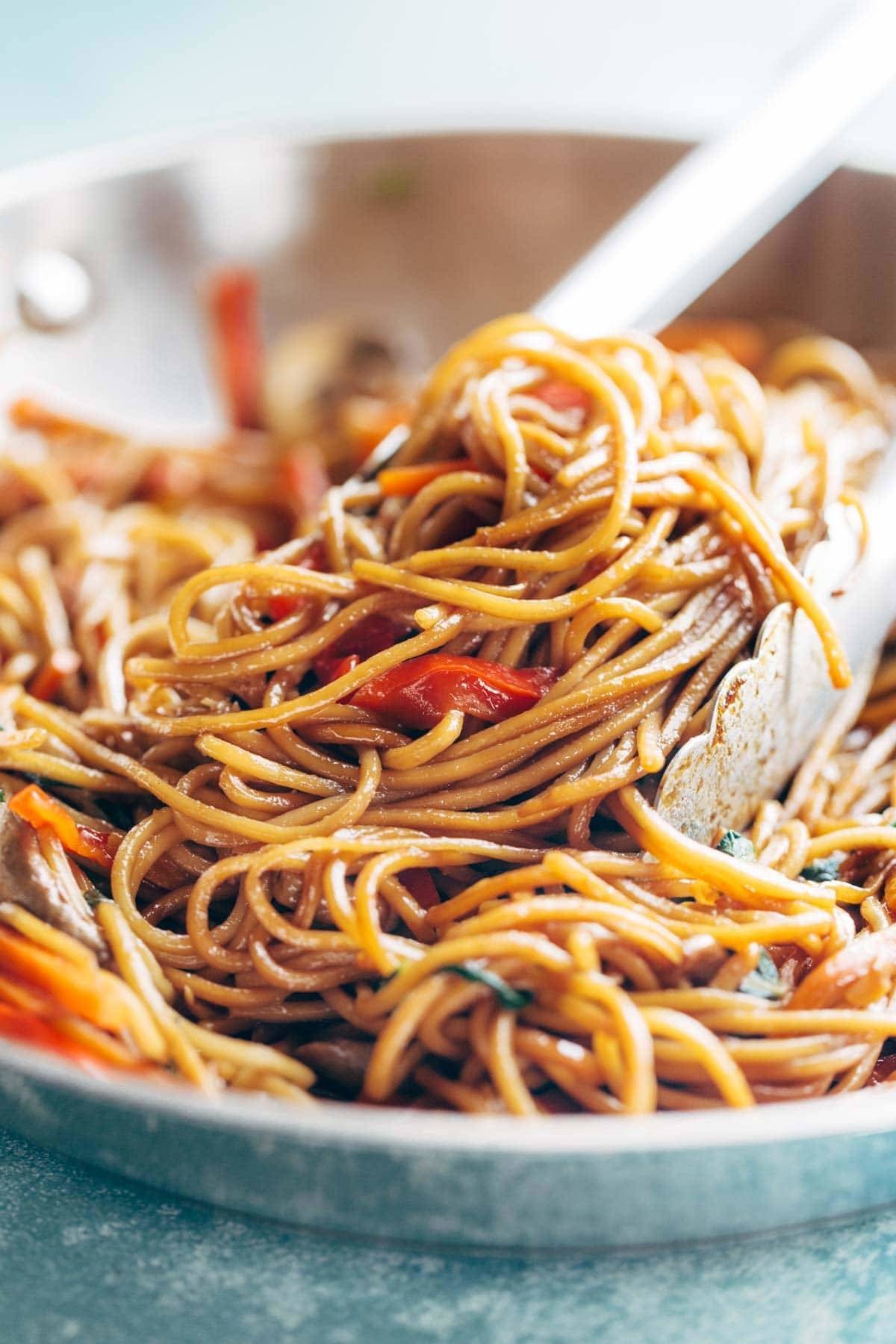 Tongs grabbing Lo Mein noodles