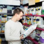 Man examining the label of dog food bag