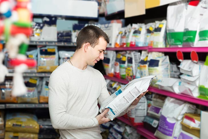 Man examining the label of dog food bag