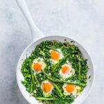 Green shakshuka in a white pan