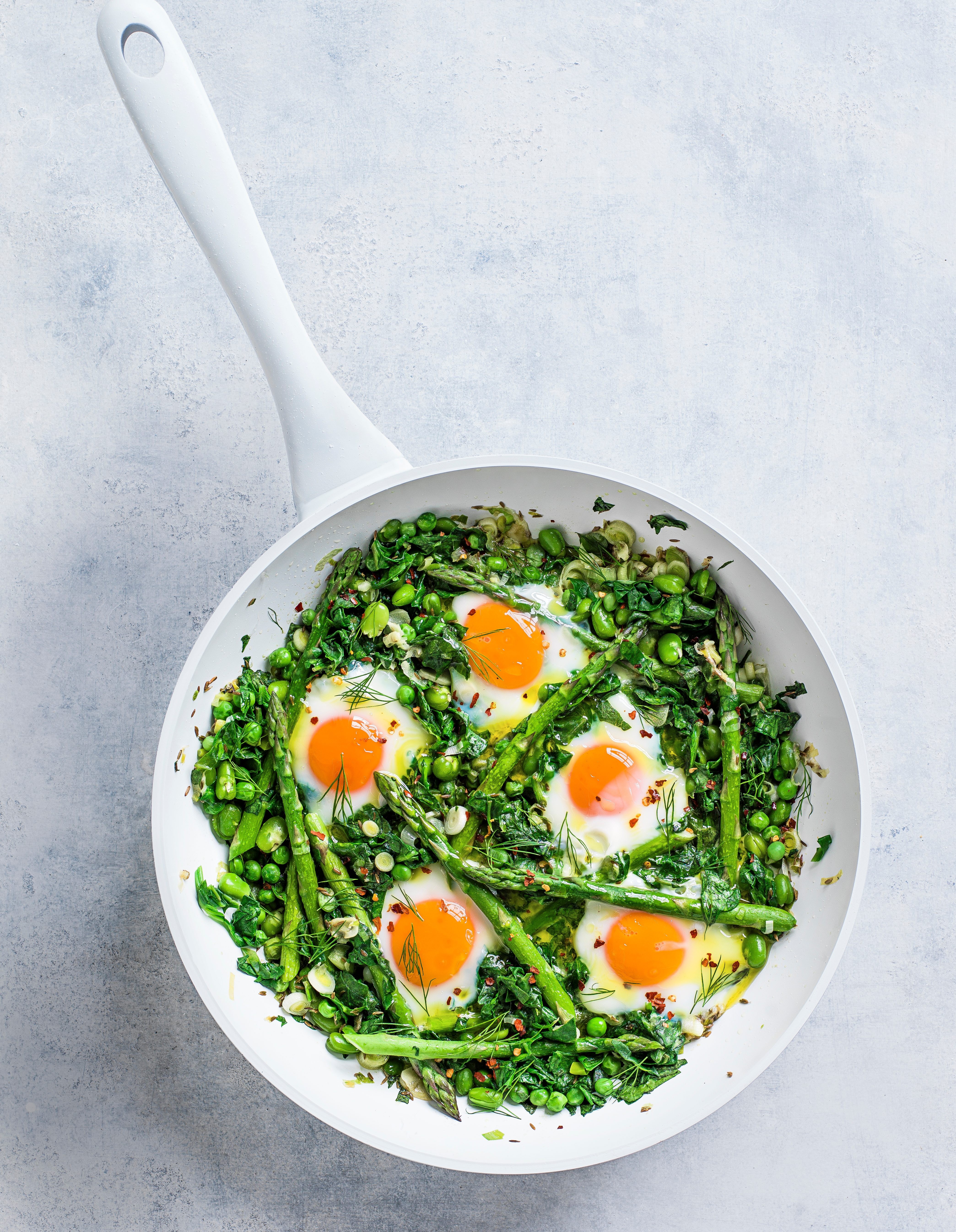 Green shakshuka in a white pan