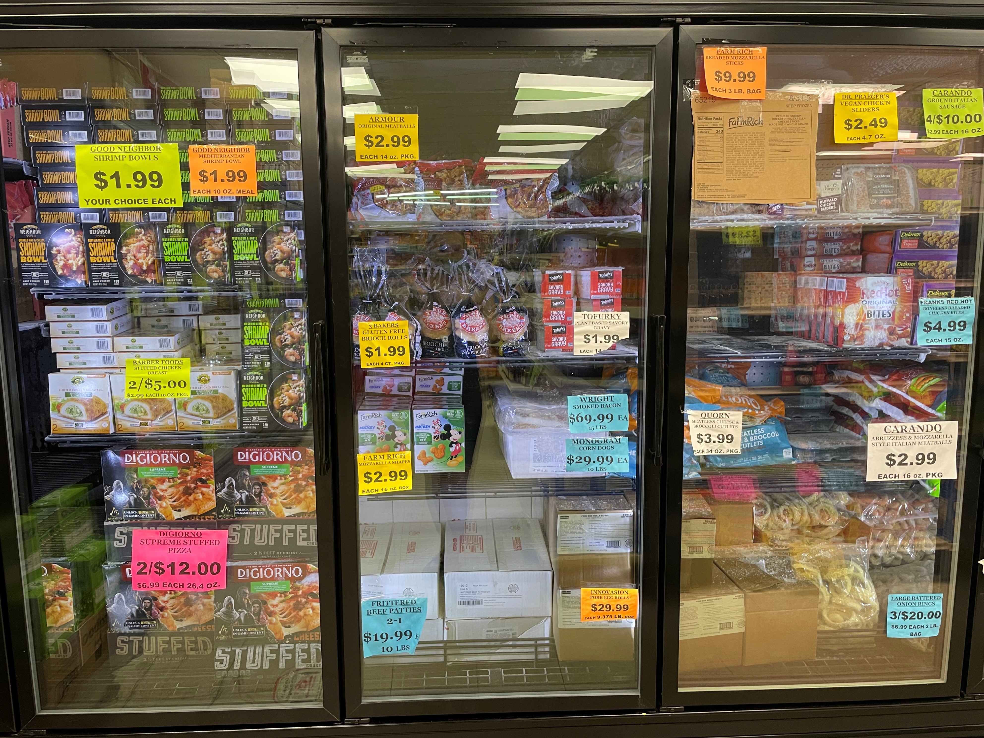 Freezer case at Mike's Discount Foods, filled with DiGiorno's supreme stuffed crust pizzas, offering a price comparison to Target