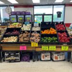 Produce section at Mike's Discount Foods, showcasing fresh apples, potatoes, and peppers with discount pricing