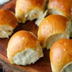 Milk bread rolls on a wooden cutting board