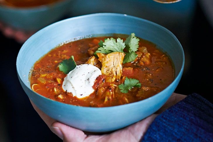 A comforting bowl of harira soup garnished with cream and coriander, a staple during Ramadan.