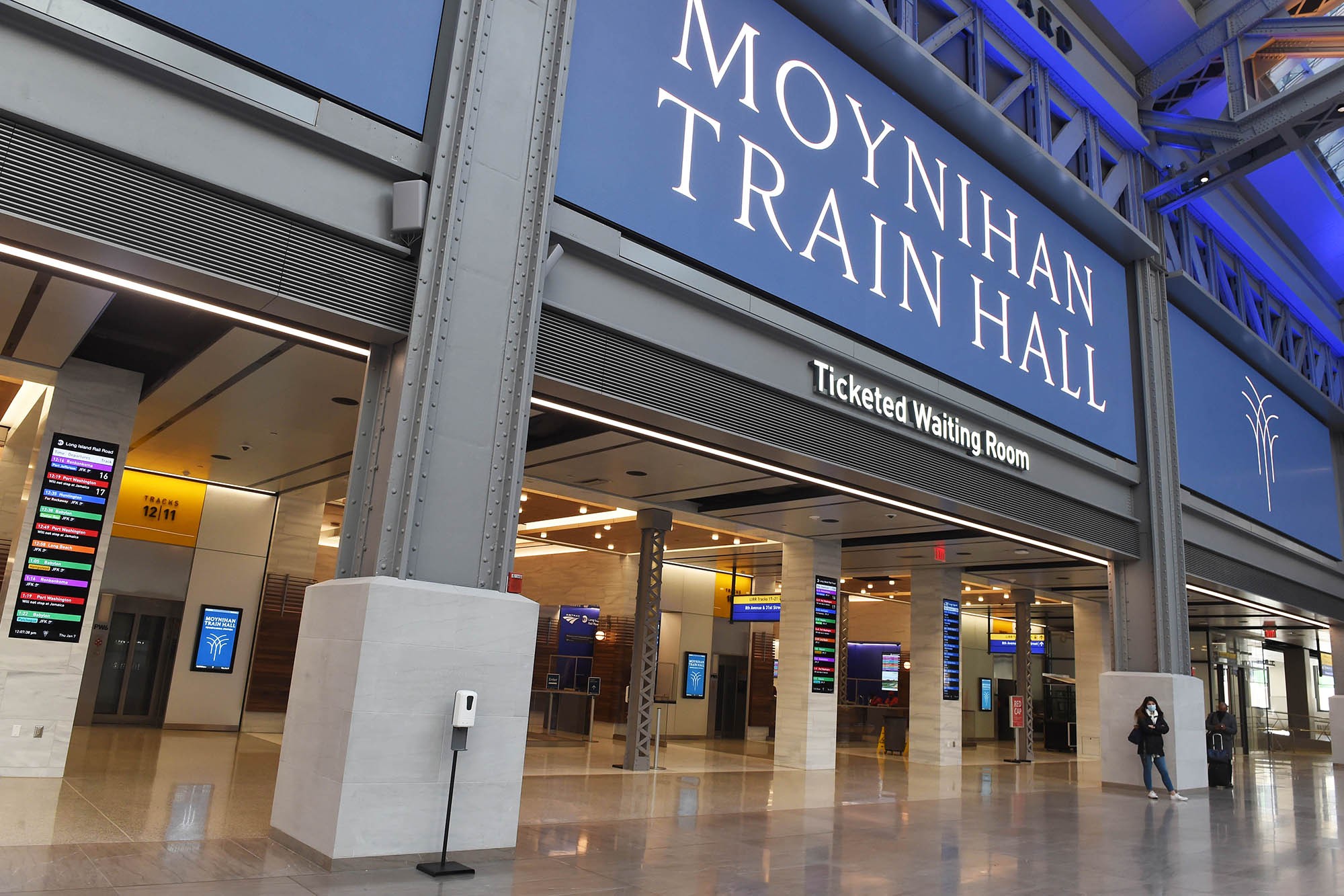 Interior view of Moynihan Train Hall with sign indicating its name.