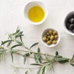 Close-up of fresh olives on a branch, showcasing their natural fruit form.