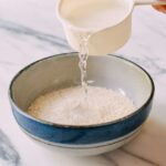 Adding water to rice in bowl for steaming, thewoksoflife.com