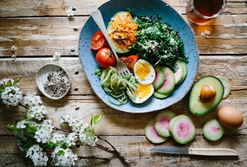 A bowl of cooked quinoa with fresh vegetables, illustrating a healthy and low-sodium whole grain option.