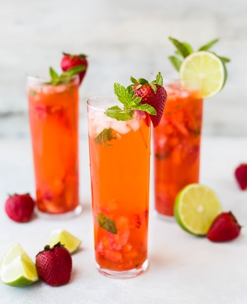 A glass pitcher filled with infused water, with slices of lemon and cucumber floating inside.