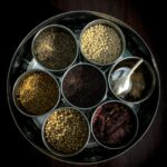 Colorful assortment of Indian spices in bowls, showcasing the variety beyond just chili peppers