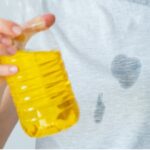 Woman cleaning food grease stain from clothes using baking soda