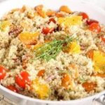 A bowl of quinoa with tomatoes and herbs