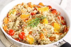 A bowl of quinoa with tomatoes and herbs