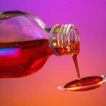 Red liquid medicine pouring =from bottle to spoon