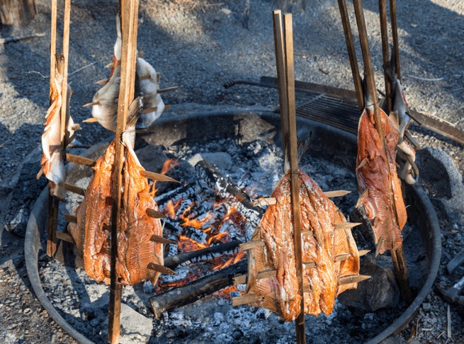 Salmon on cedar stakes: A time-honored Native American cooking method, infusing the fish with the smoky aroma of cedar and reflecting a deep connection to nature.