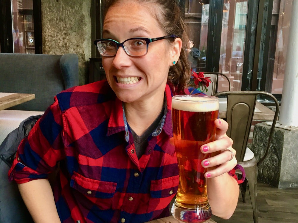 A woman holds a glass of beer at Bell in Hand Tavern