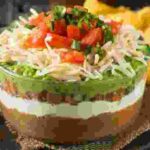 Seven layer dip is perfect for tailgate parties as it's easy to prepare and full of flavor
