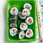 Assortment of fresh and colorful sushi rolls on a dark wooden board