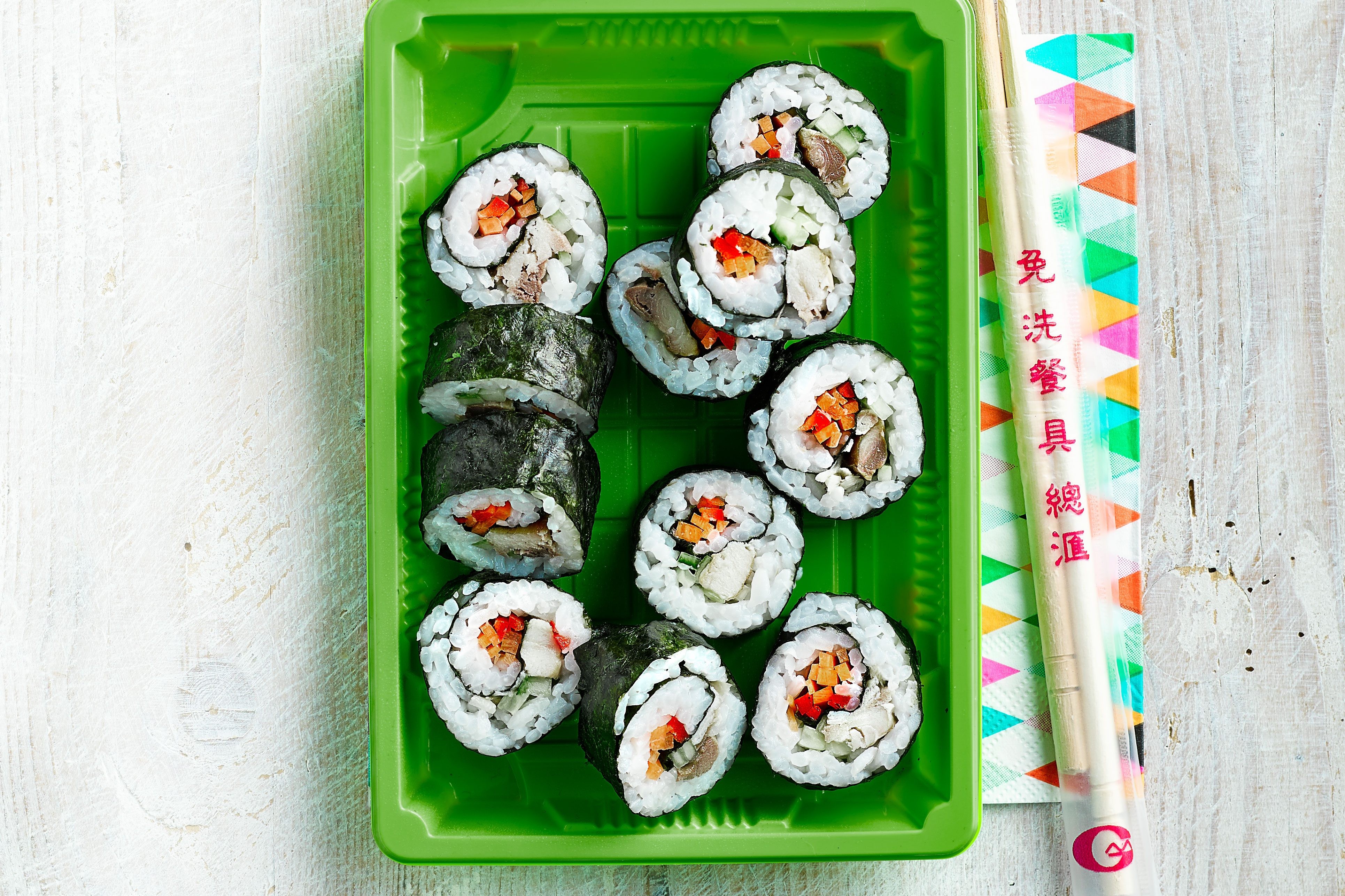 Assortment of fresh and colorful sushi rolls on a dark wooden board