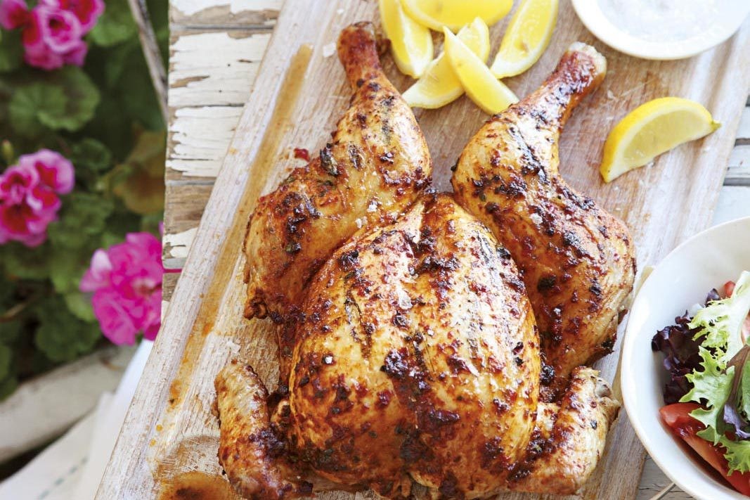 Spatchcock peri peri chicken on a wooden board