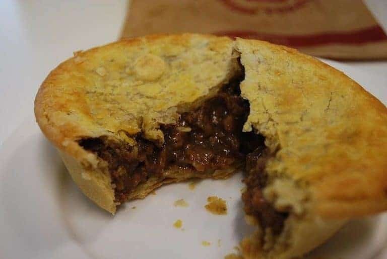 Aussie Meat Pie, a savory pie filled with minced meat, gravy, and vegetables, showcasing its golden crust and hearty filling.