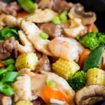 Close-up of chicken and corn in a takeout-style stir-fry, showcasing the savory sauce.