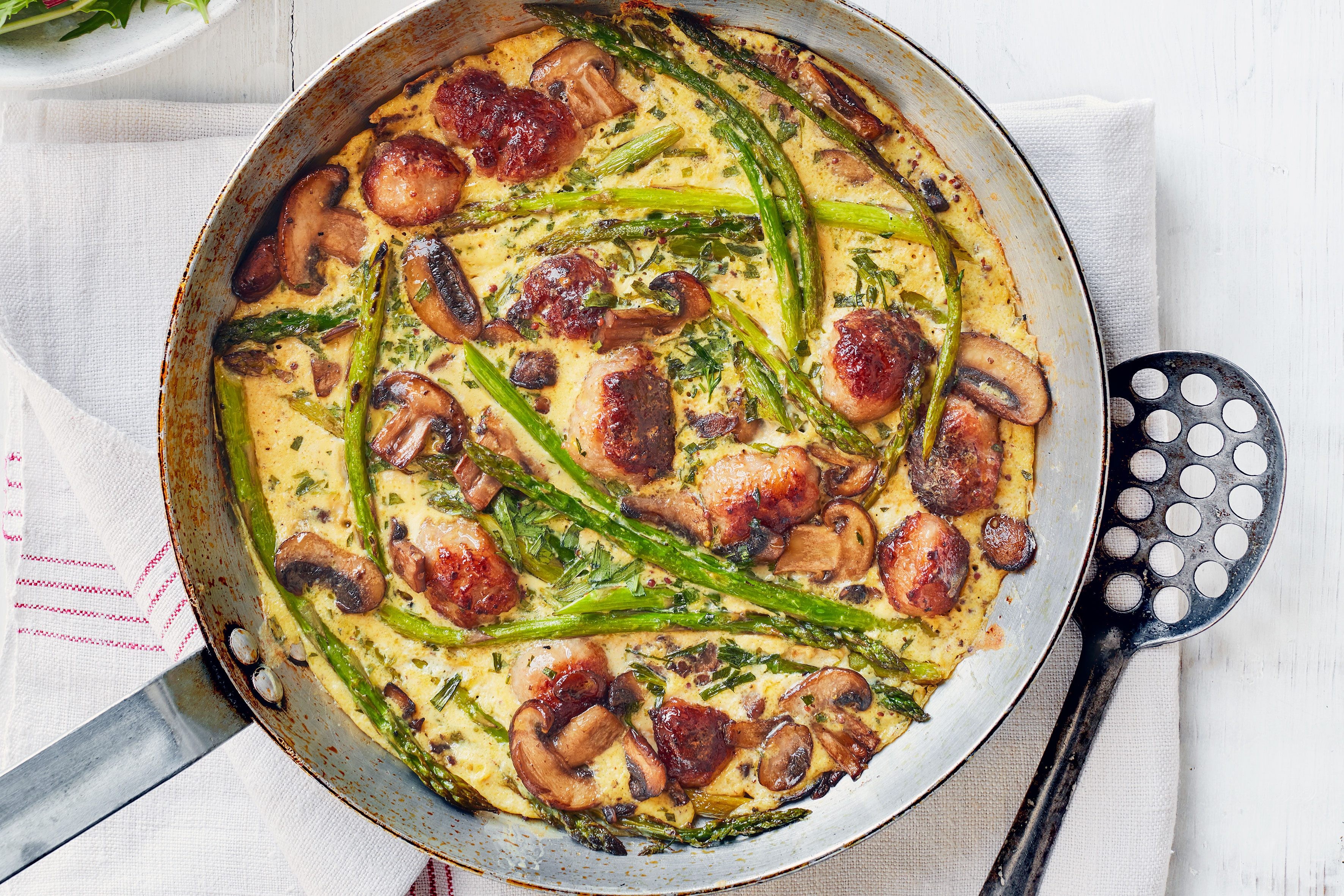 Tarragon, sausage, and mushroom frittata in a pan.