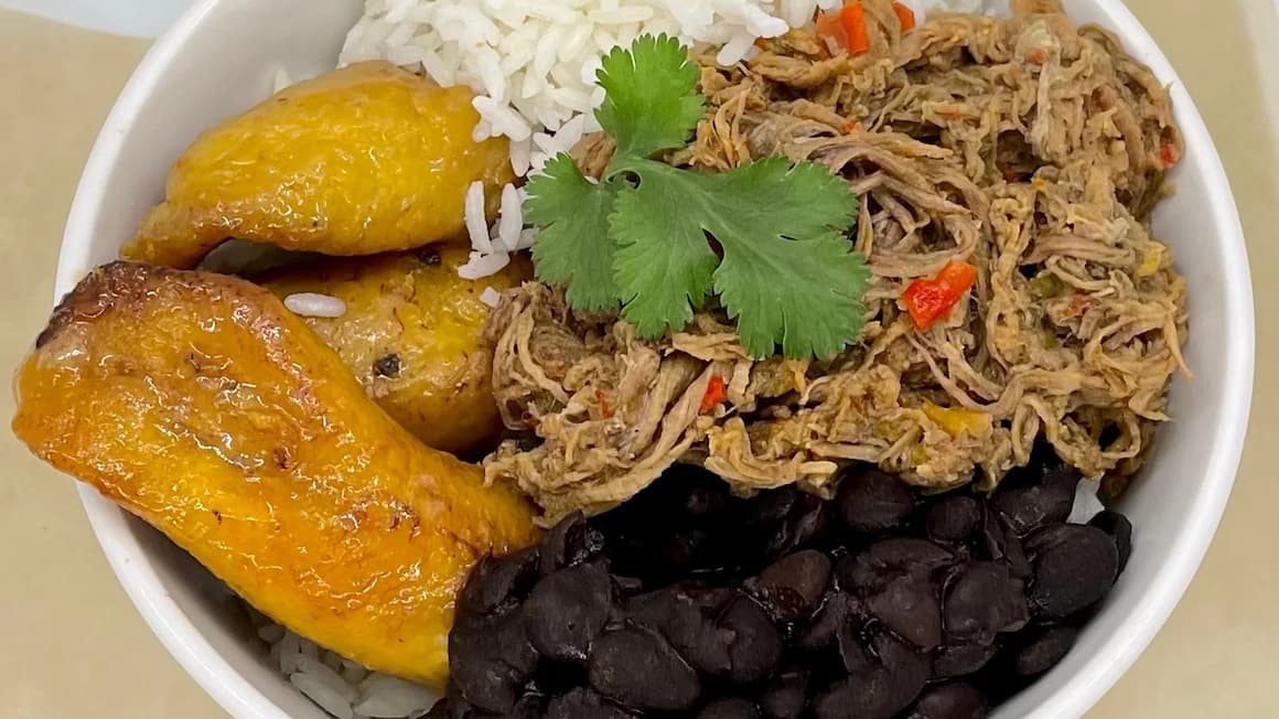 Pabellón Criollo featuring rice, black beans, shredded beef, and fried plantains