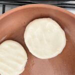 Venezuelan Arepas being prepared, showcasing their golden-brown exterior and diverse fillings