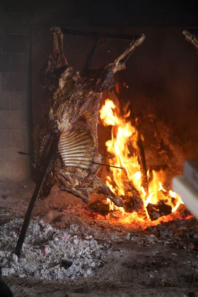 Lamb roasting on a spit over an open fire in Patagonia