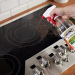 Baking soda and vinegar mixture fizzing on a glass stove top, demonstrating a natural cleaning solution