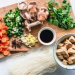 Chopped mushrooms carrots ginger garlic tofu and greens