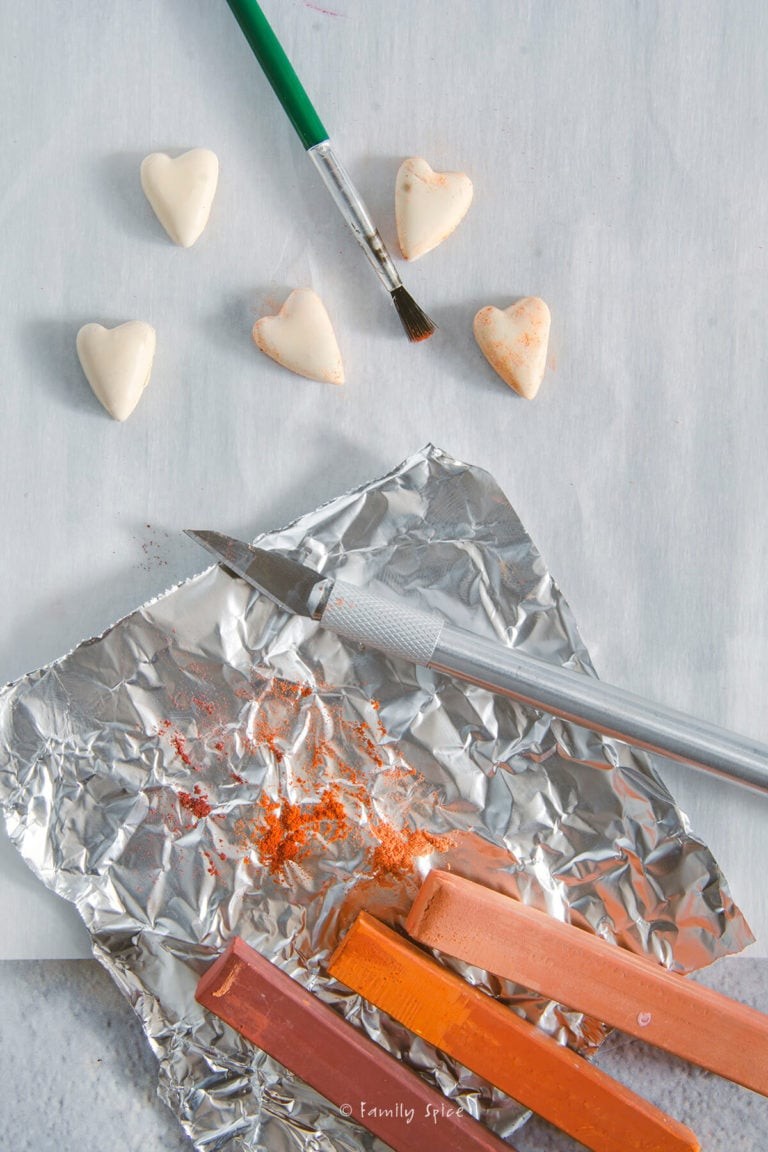 Using a mix of brown pastel shavings to brush onto mini heart cookies