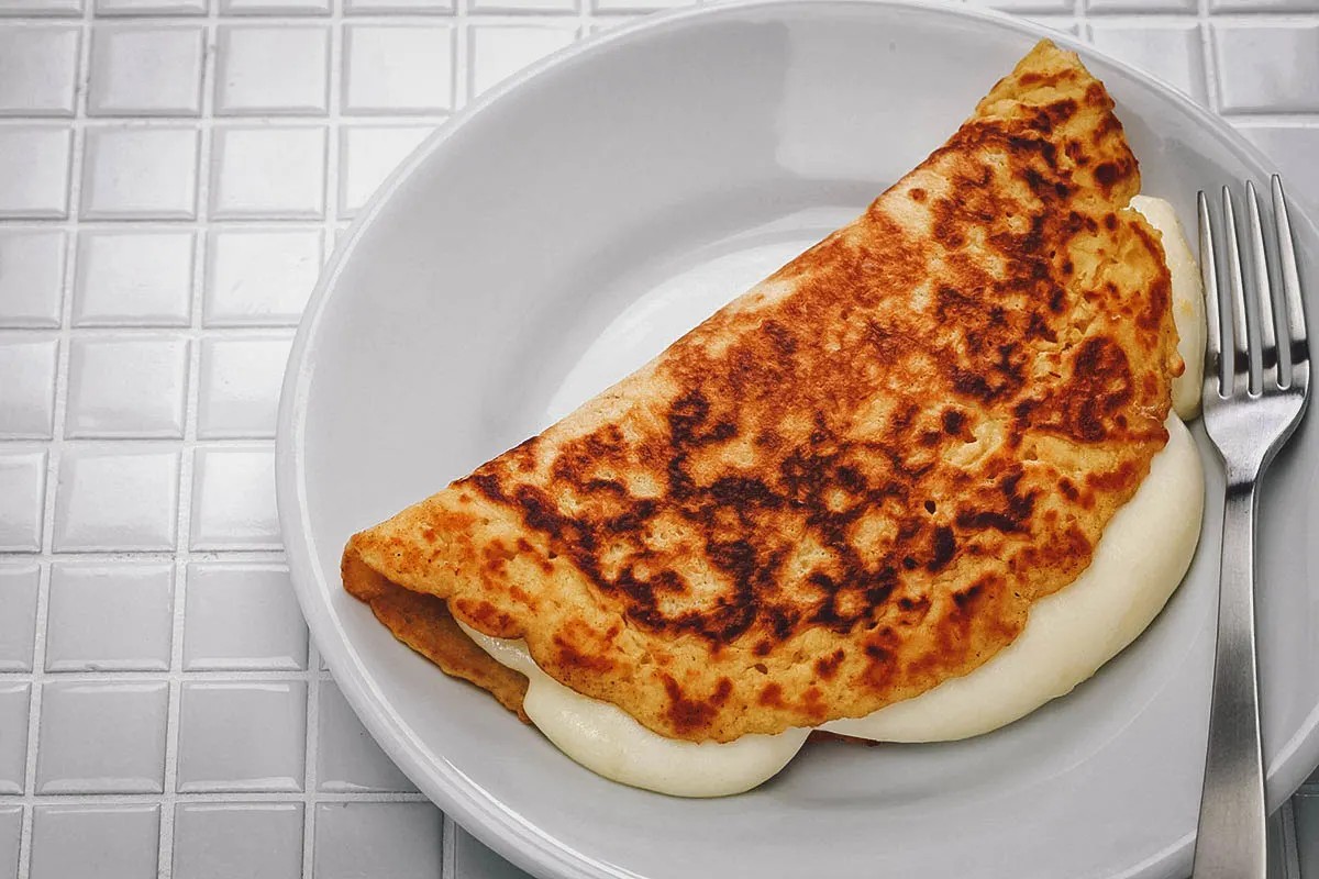 A cachapa filled with queso de mano, showcasing its sweet corn flavor and slightly crispy texture