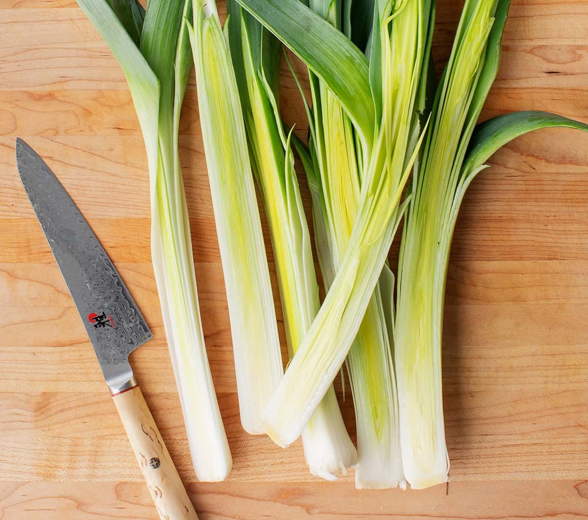 Halved leeks on a cutting board